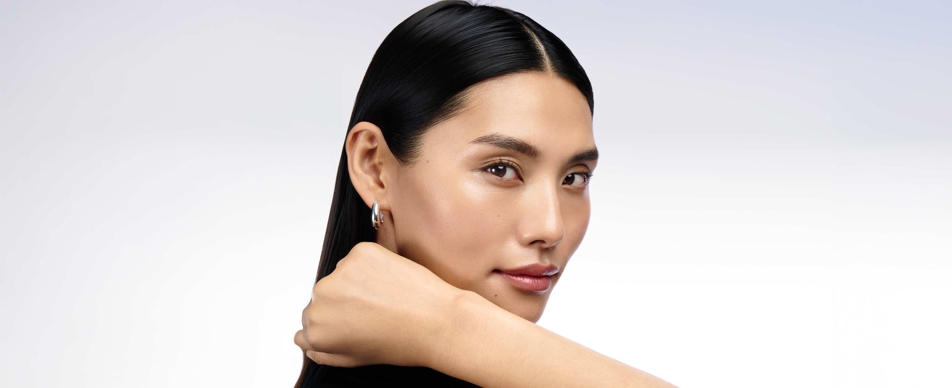 Close-up portrait of a woman with smooth, plump, and balanced oily skin after applying lightweight hyaluronic acid.