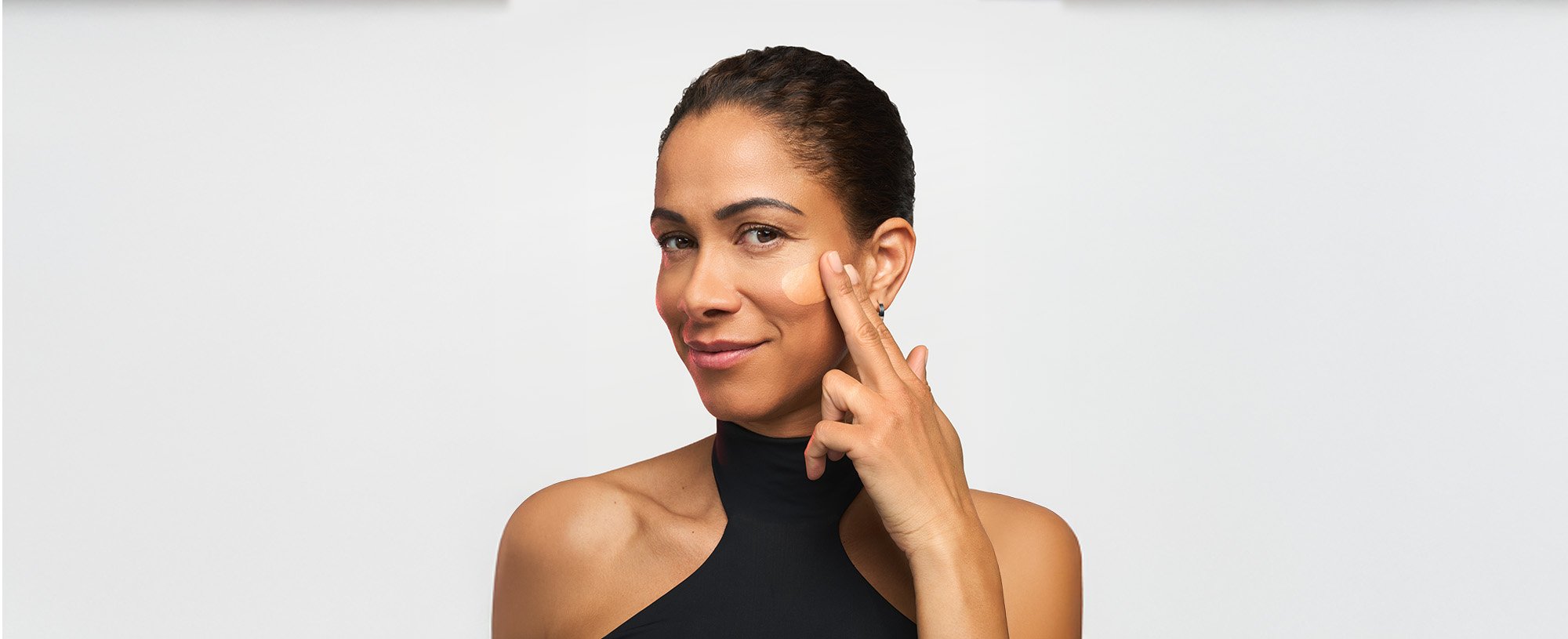 A woman with a radiant complexion applying a dermatologically tested serum, illustrating the clinical application of Revitalift for hyperpigmentation and dark spot correction.