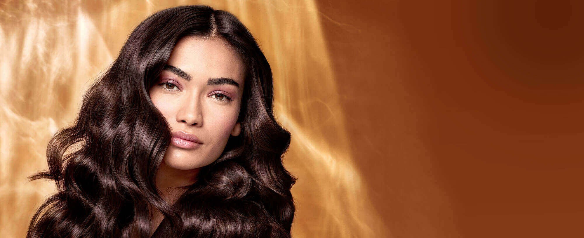 Extraordinary Oils Hero Image Model with long brown hair