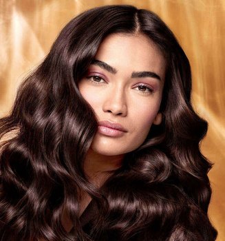 Extraordinary Oils Hero Image Model with long brown hair