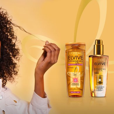 Elvive extraordinary oil bottles shots and model with very defined curly hair